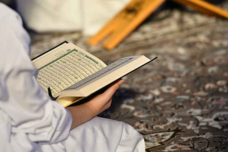 A serene person reading the Quran on a traditional Muslim prayer mat, focusing on the holy book, Best way to memorize Quran